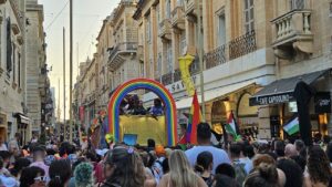 Malta Pride attendees celebrate with rainbow flags in the historical city center.