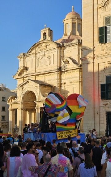 Malta Pride attendees celebrate with rainbow flags in the historical city center.