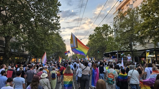 Activists and participants marching with banners in the Belgrade Pride (Parada Ponosa) protest walk in Serbia, demanding LGBTQ+ rights and legal reform.