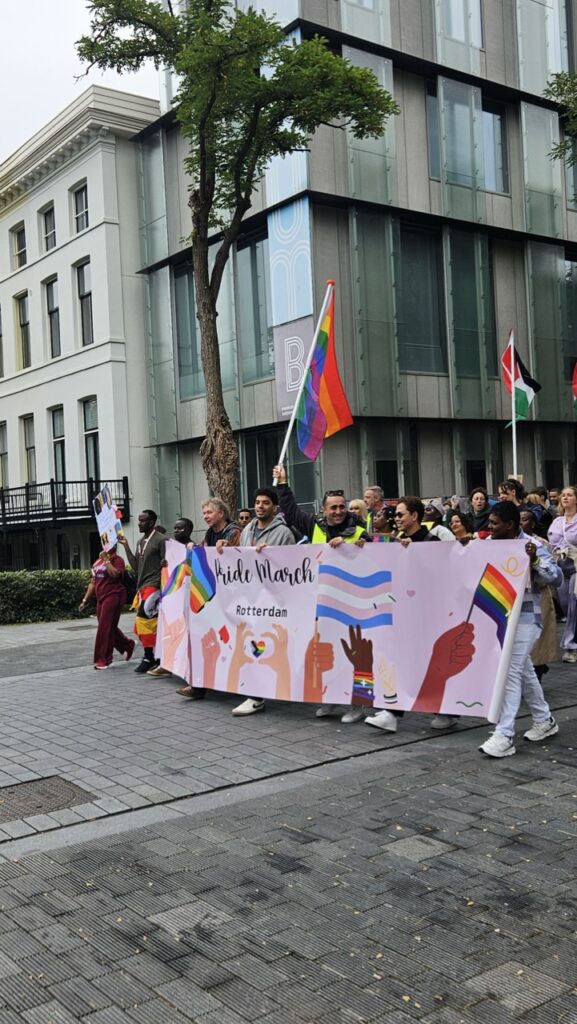 Front of the Rotterdam Pride parade with participants carrying a large banner, leading the LGBTQ+ march through the city.