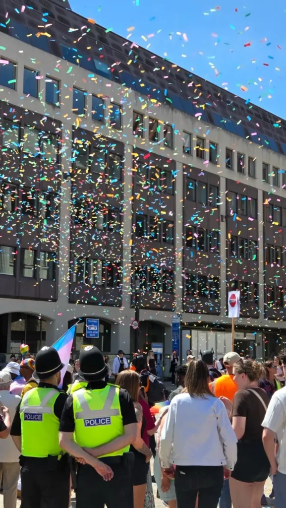 Confetti falls over Birmingham Pride crowds and police officers during the parade as people celebrate in the city centre.