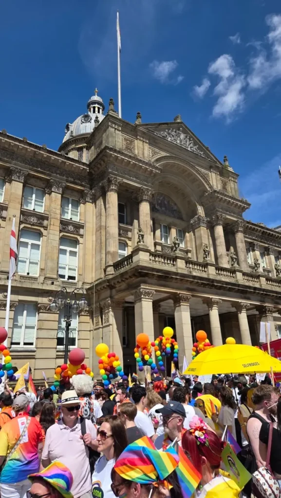 People gather at Victoria Square in Birmingham before the start of the Birmingham Pride parade, waving rainbow flags and celebrating together.