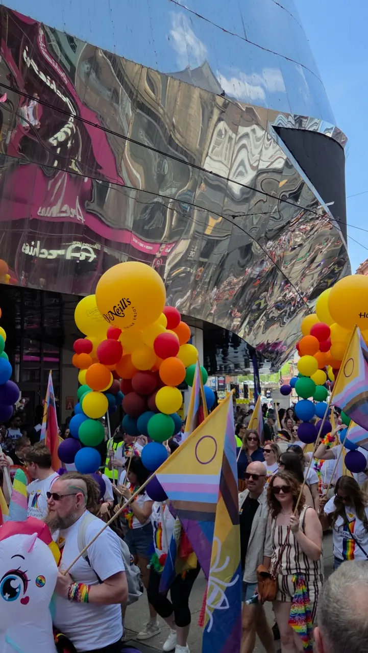 Birmingham Pride parade with floats, rainbow flags and thousands of spectators in the city centre.