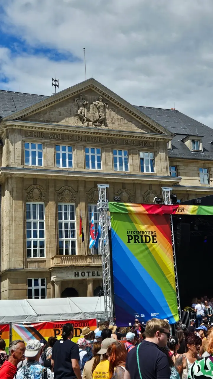 Visitors celebrating at the Luxembourg Pride festival square with rainbow flags and entertainment